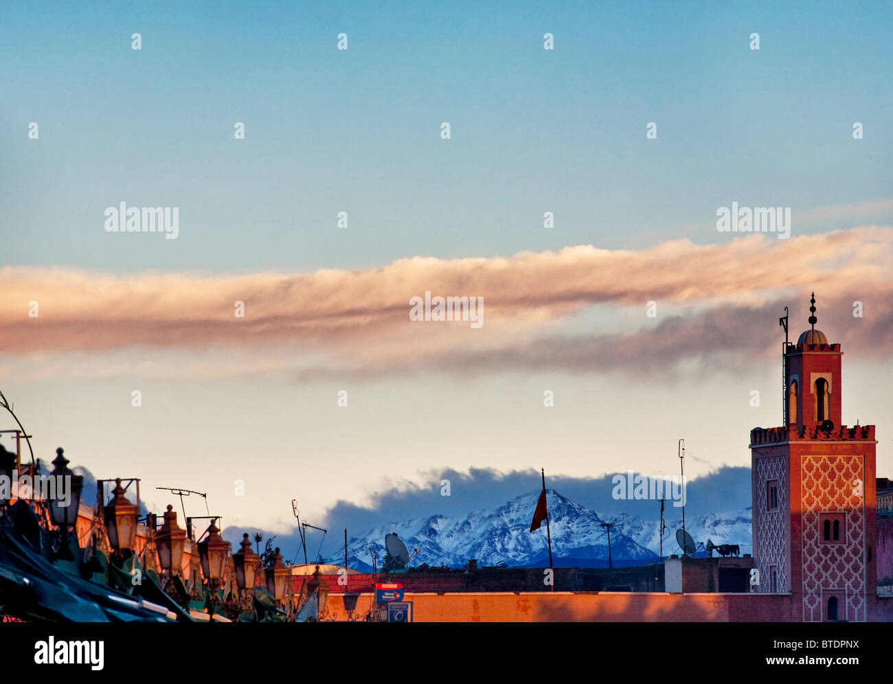 Marrakesch-Marktplatz mit dramatischen schneebedeckten Atlas-Gebirge im Hintergrund Stockfoto