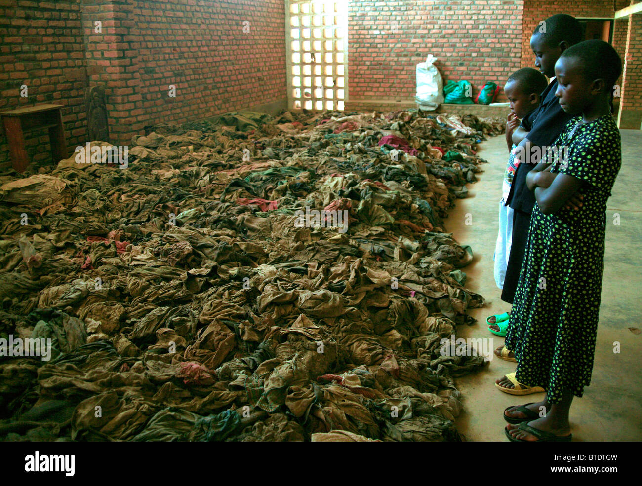 Kinder stehen in einer Kirche im ländlichen Ruanda und mit Blick auf Reste Opeople getötet während des Völkermordes 1994 Stockfoto