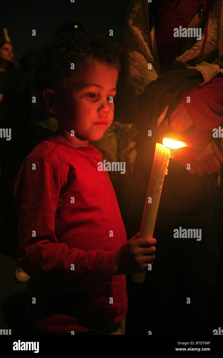 Ein kleines Kind mit einer brennenden Kerze auf eine Mahnwache für und gegen fremdenfeindliche Gewalt Stockfoto