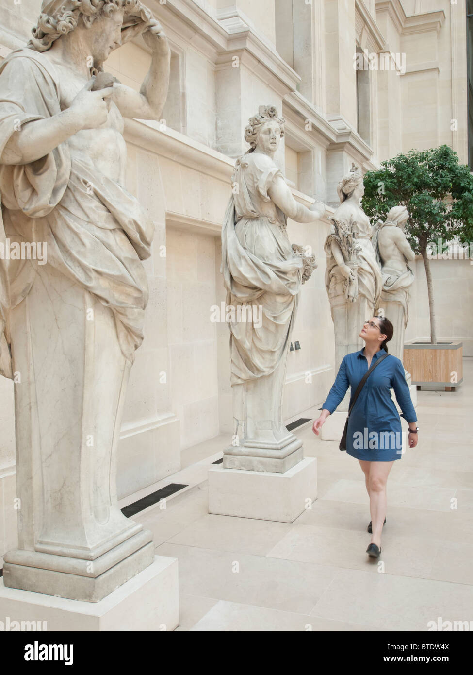 Frau betrachten Skulpturen im Louvre Museum in Paris Frankreich Stockfoto