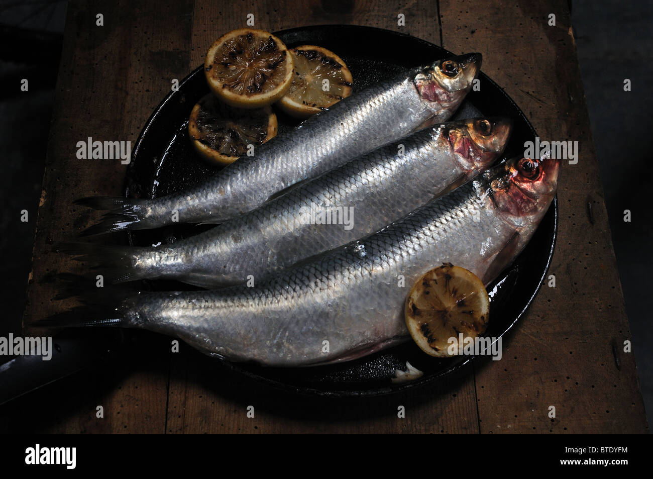 Pfanne gebratenen Heringe zum Abendessen mit Zitrone Stockfoto