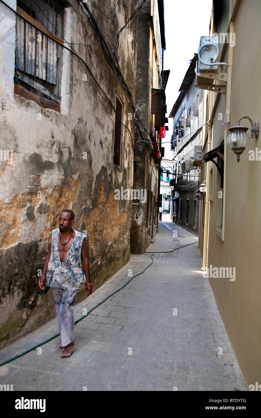 Lokale Mann zu Fuß entlang einer schmalen Straße in Stonetown Stockfoto