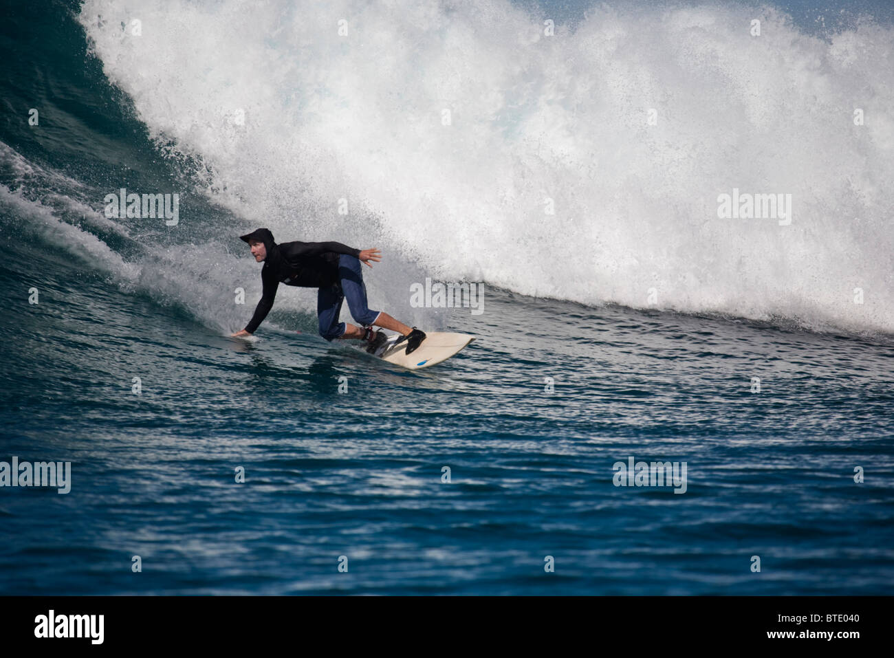 Surfer schiefen Vorwort auf seinem Brett nachgestellte einerseits im Wasser Stockfoto