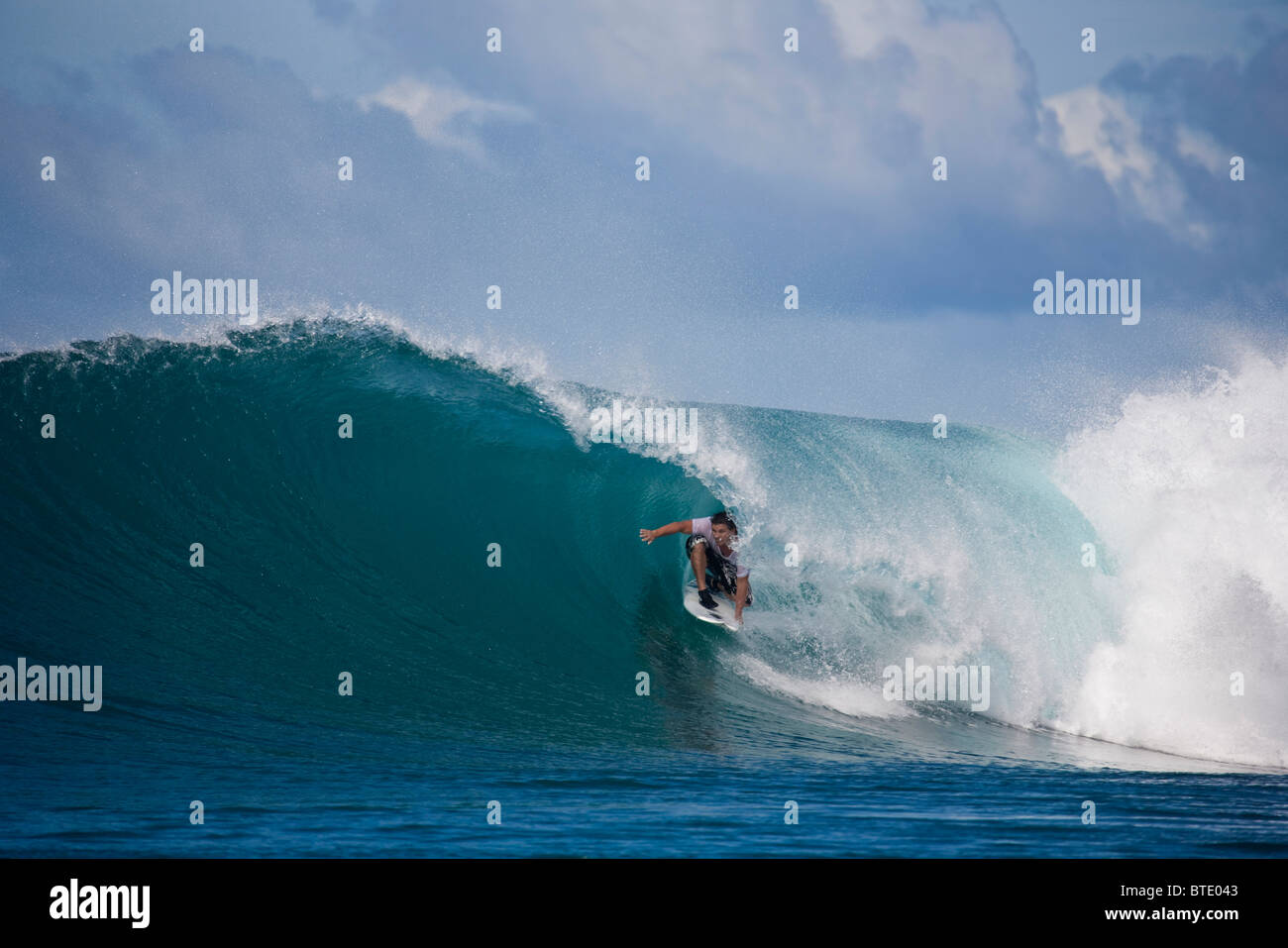 Mann kniet auf seinem Surfbrett dabei, in einer brechenden Welle erwischt werden Stockfoto