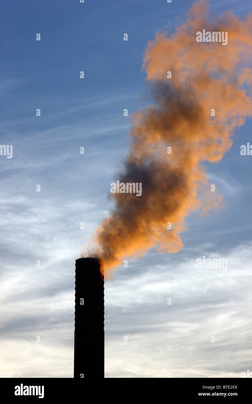 Fabrikschornsteinen, Morgenlicht, Rauch herauskommen. Stockfoto