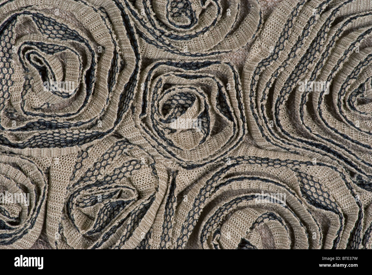 Stoffskulptur. Aus Baumwolle gestricktem Polyester werden geformte Stoffe in runden Rosettenformen gestrickt. Stockfoto