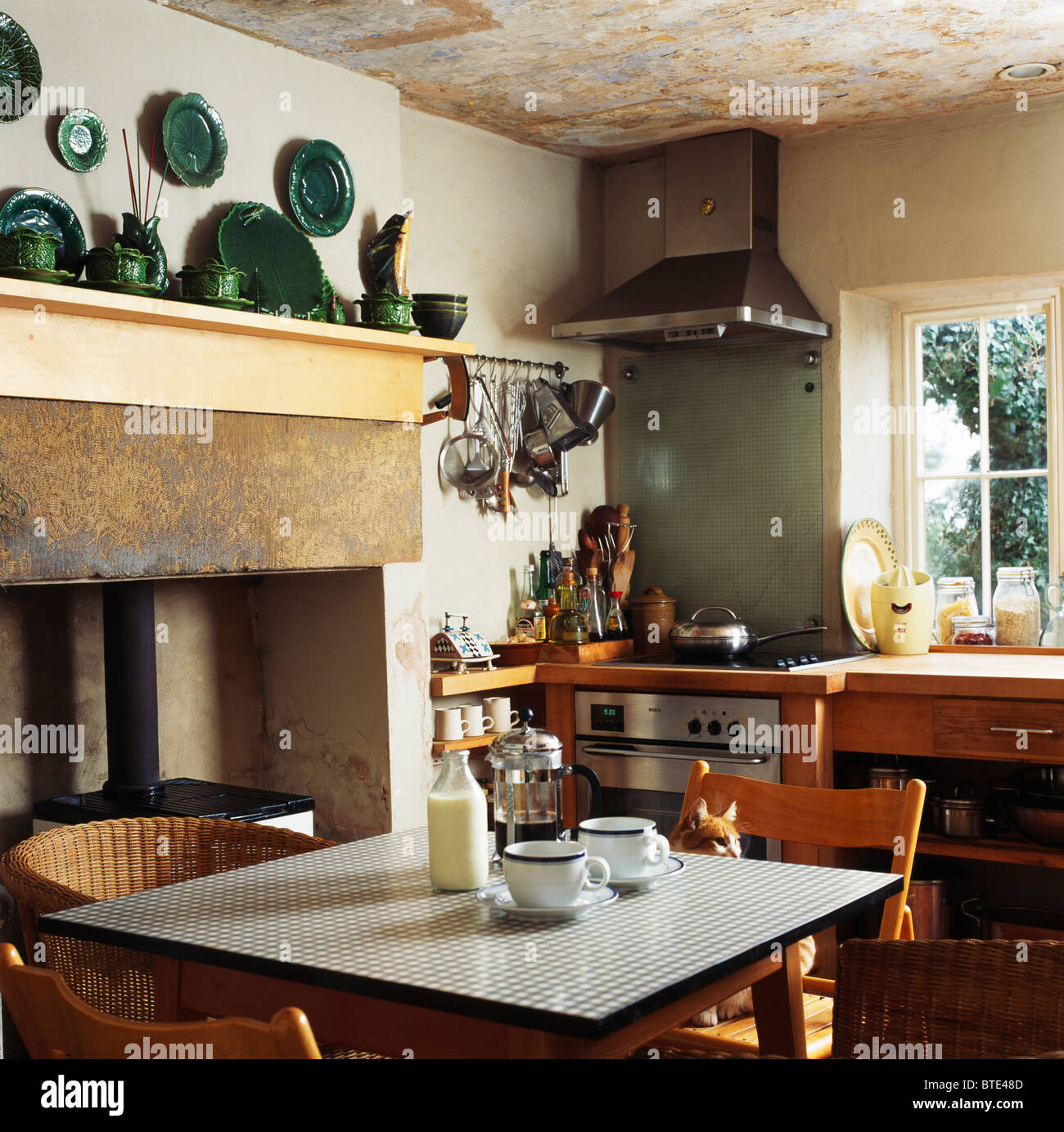 Milch-Flasche und Becher auf aufgegebenes Formica-Spitze Tabelle in kleinen Cottage-Küche mit einem großen Kamin Stockfoto