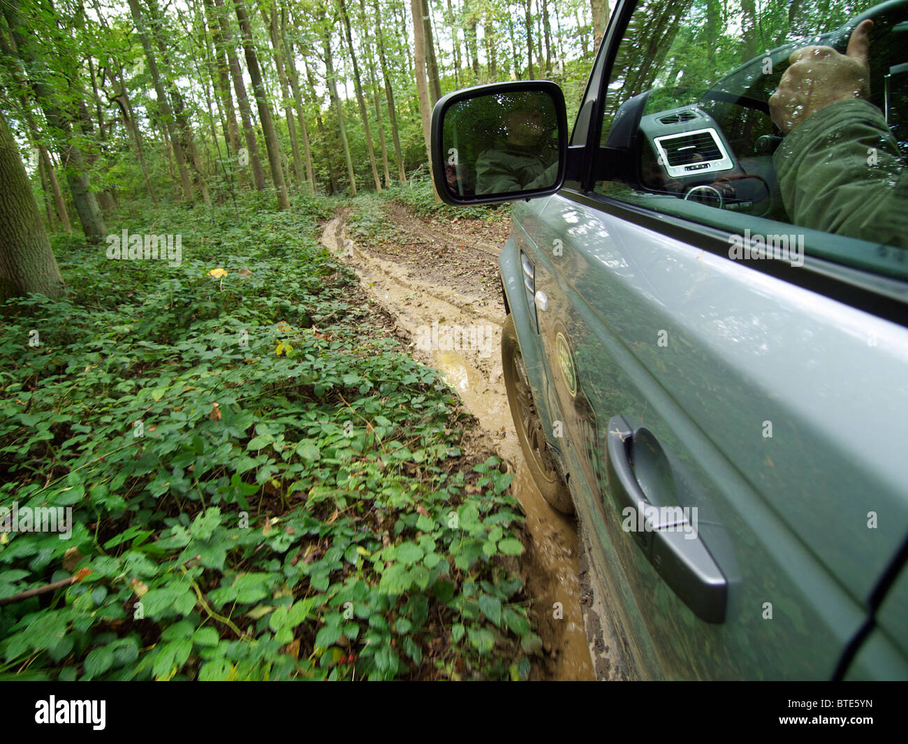 Range Rover Sport auf einem extrem matschig und rutschig Weg durch einen Wald fahren. Domaine d'Arthey, Belgien Stockfoto