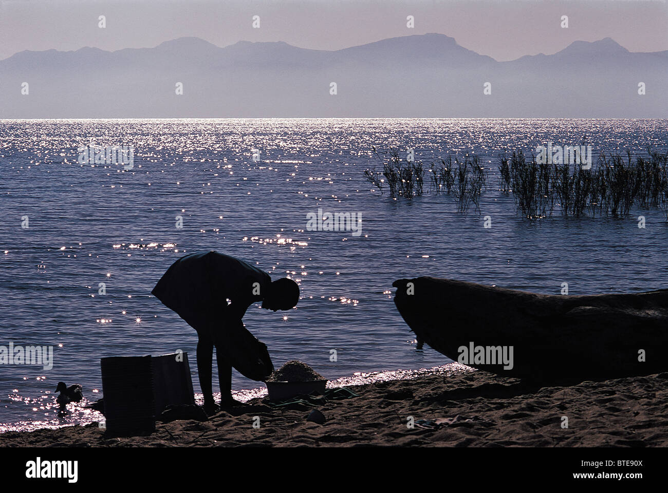 Ein Fischer am Ufer des Lake Malawi am frühen Abend Stockfoto