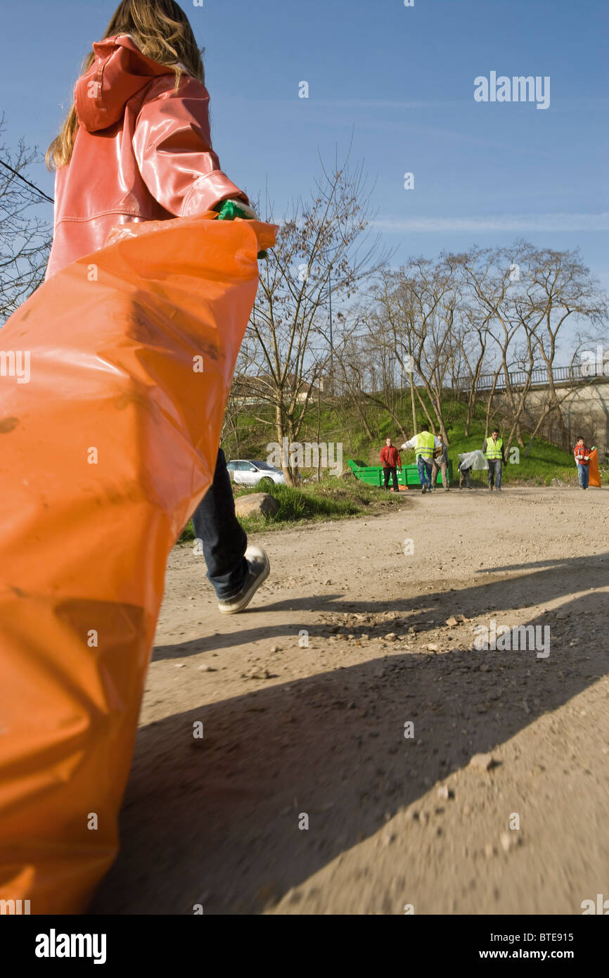 Abholung am Straßenrand Wurf ziehen vollen Müllsack Stockfoto
