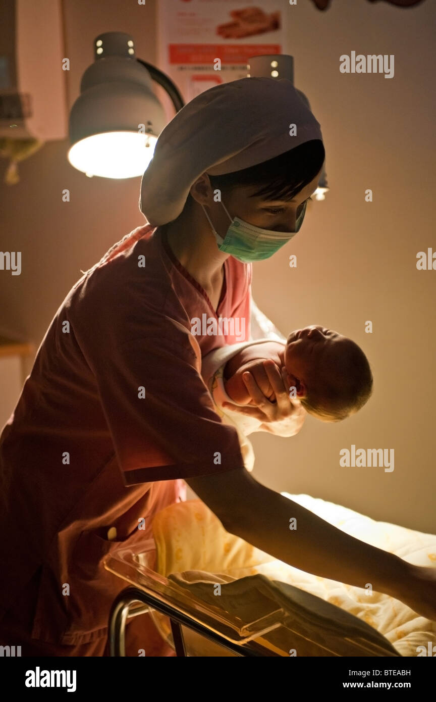 Krankenschwester, neugeborenes Baby halten und setzen sie ins Bett Stockfoto