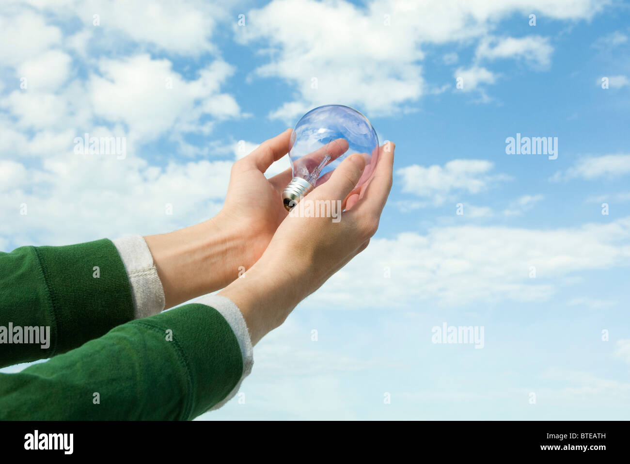 Person, die Glühbirne in der hohlen Hand Stockfoto
