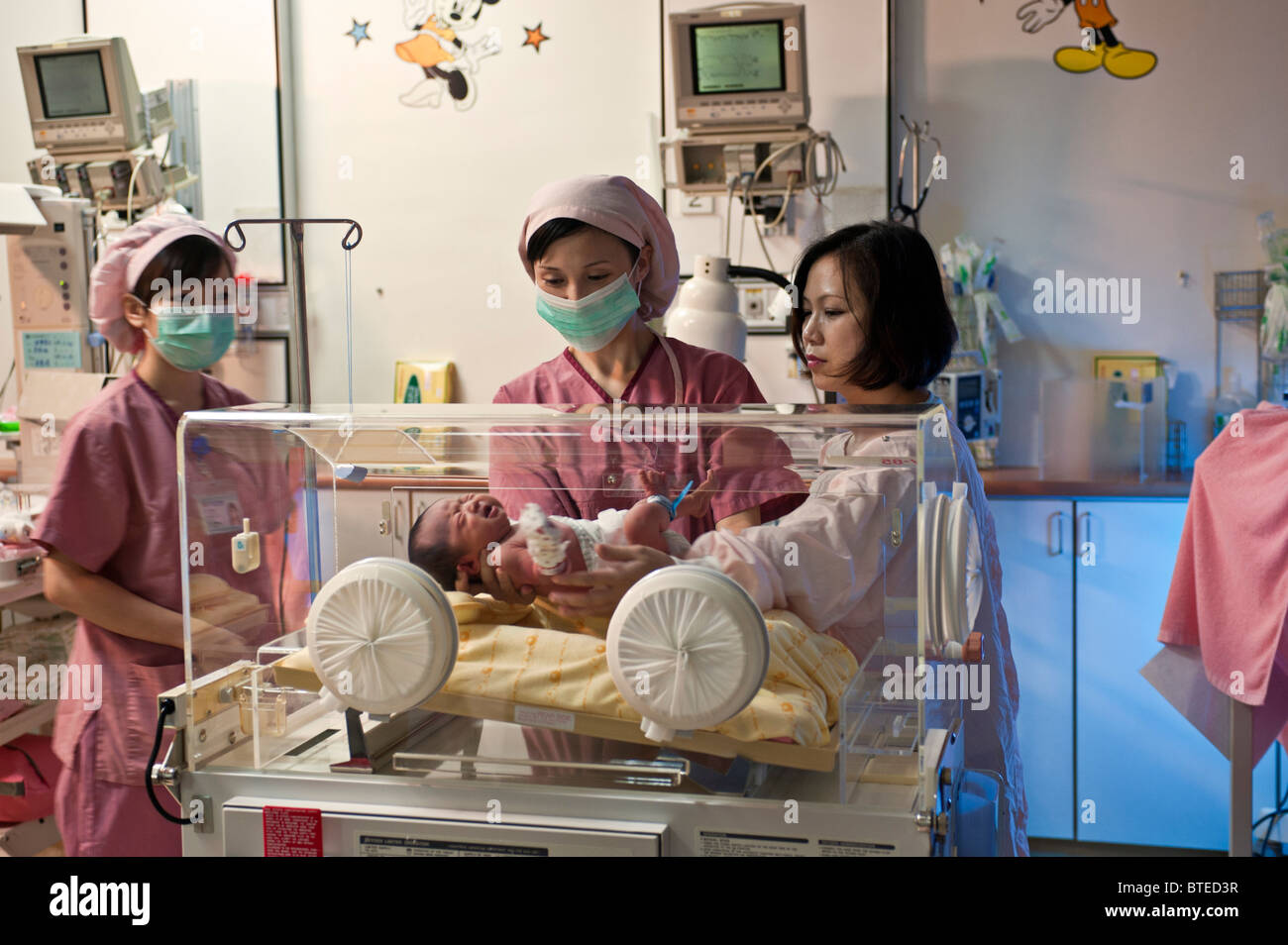 Neugeborenes Baby im Inkubator von Mutter setzen Stockfoto