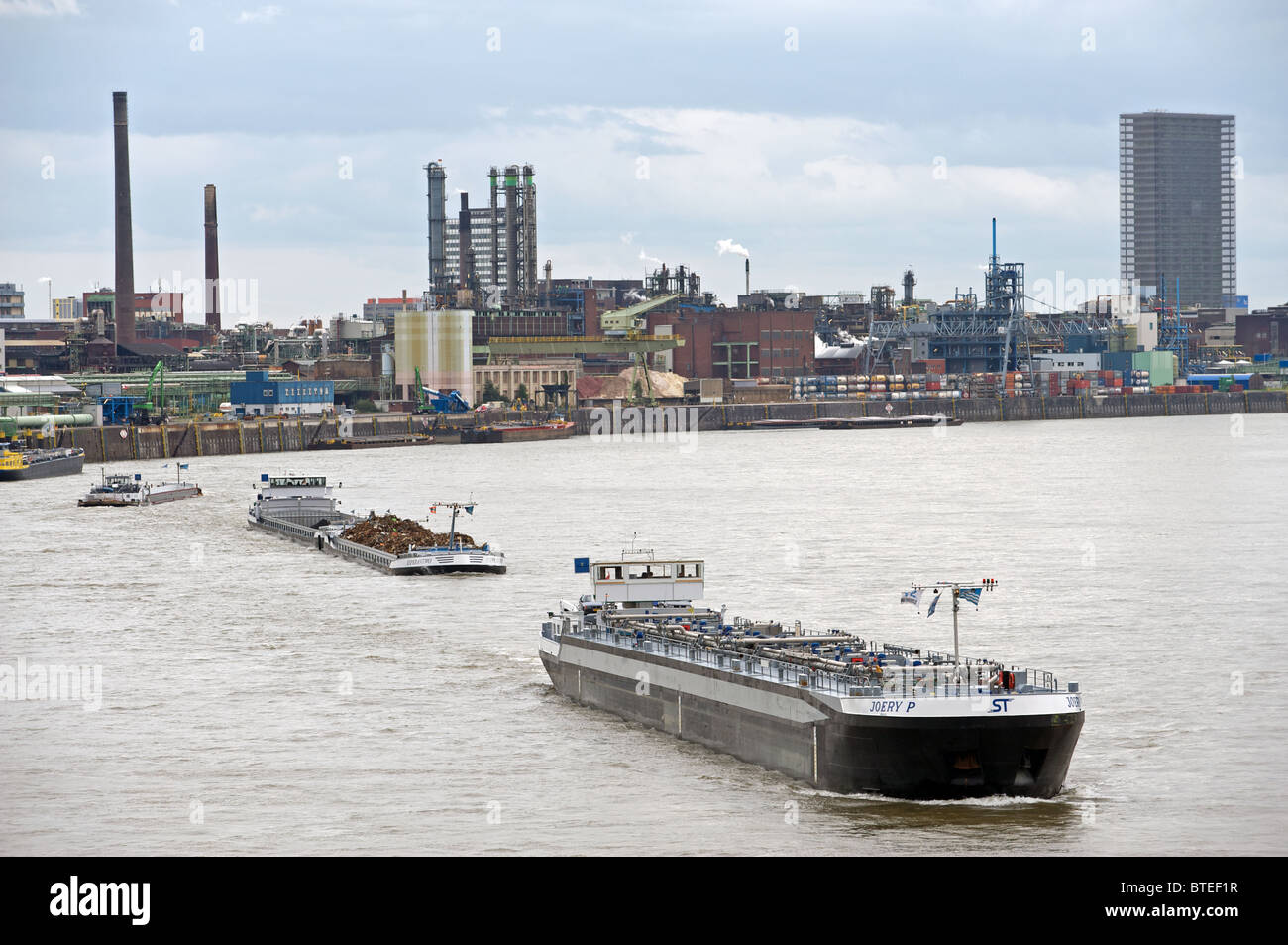 Kommerzielle Schiffe segeln auf dem Rhein vorbei an die chemische Fabrik von Bayer, Leverkusen, Deutschland. Stockfoto