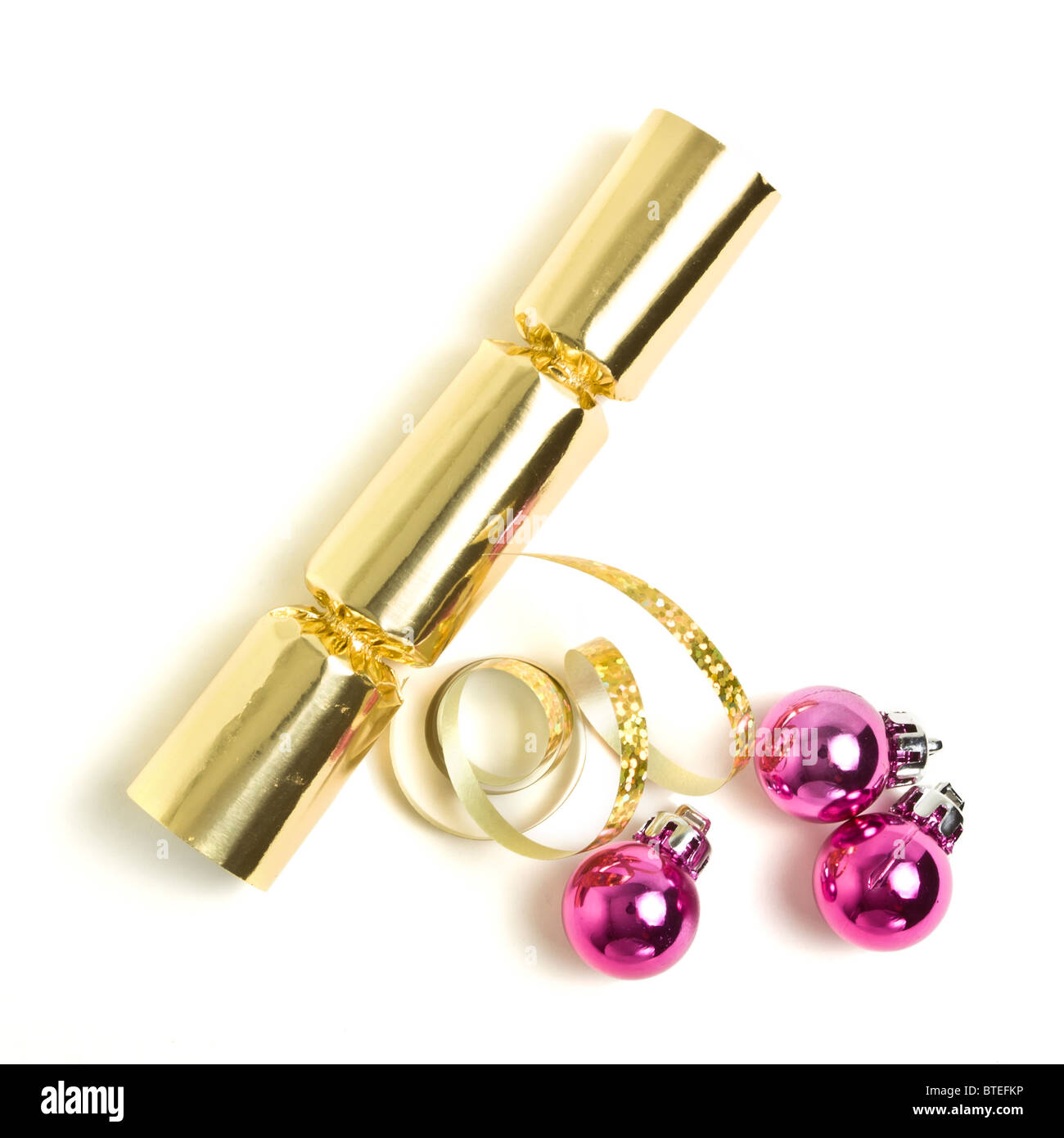 Golden Christmas Cracker mit Schleife und rosa Kugeln von oben. Stockfoto
