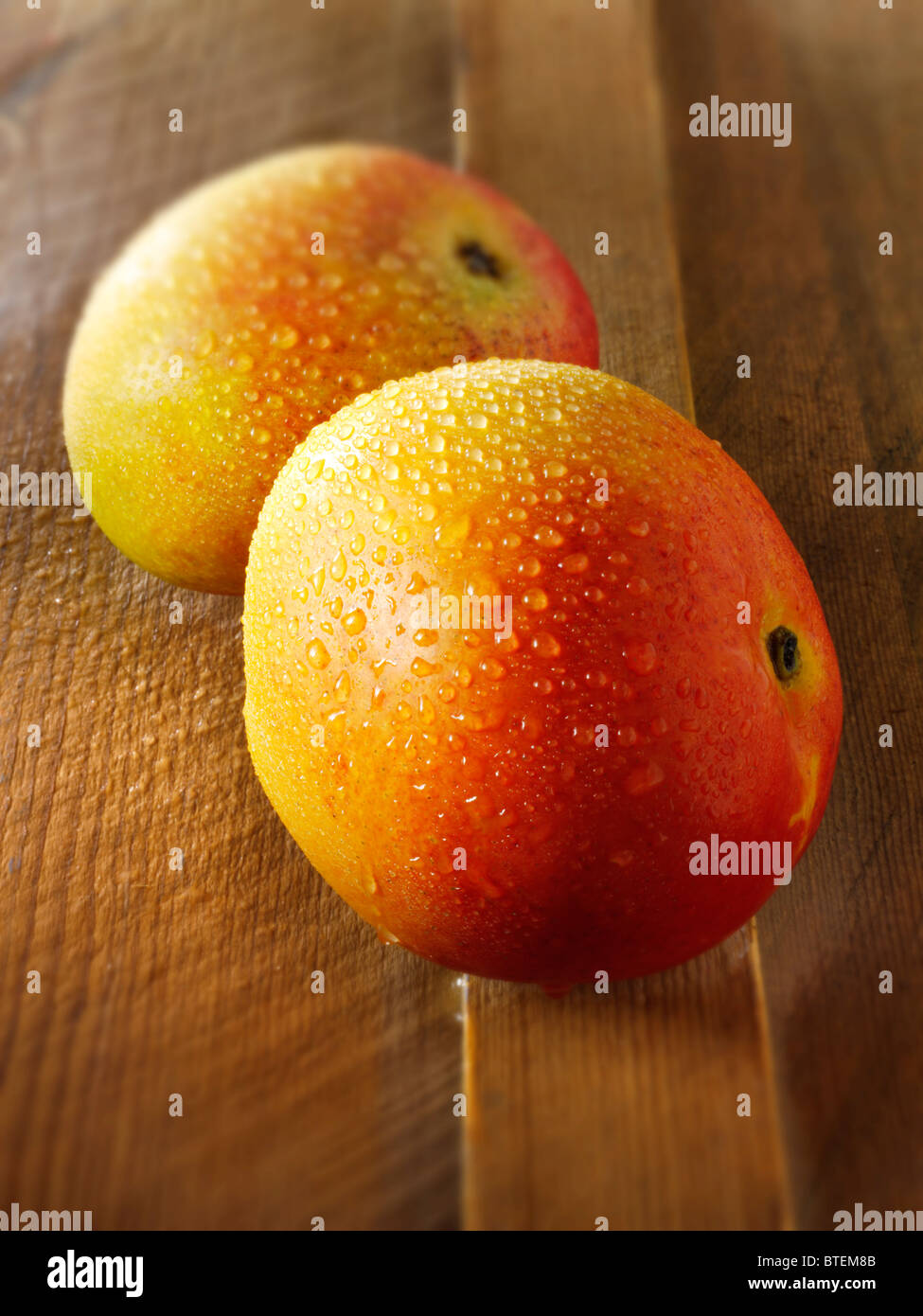 Frische ganze Mini-Mango auf einem Holztisch Stockfoto