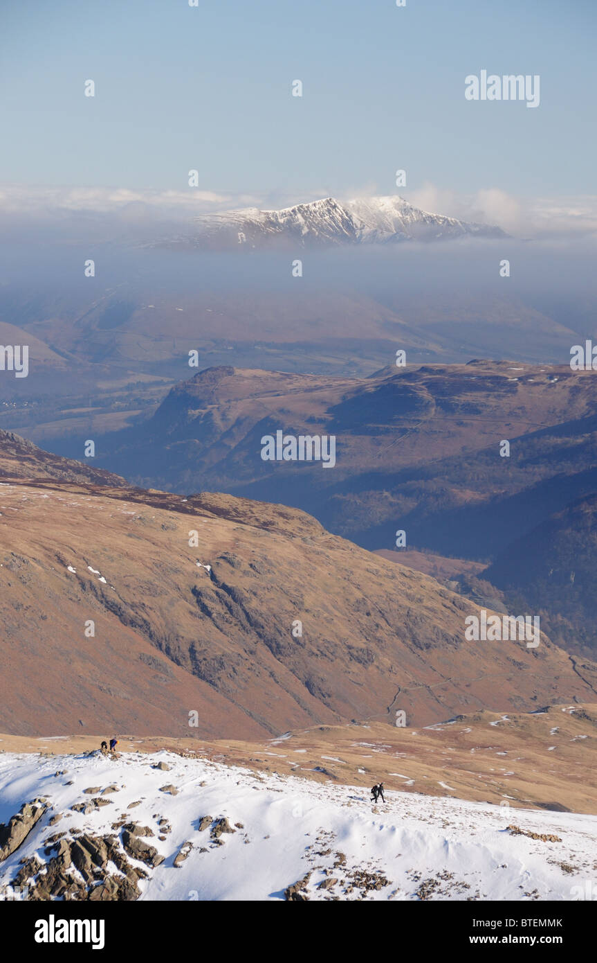 Wanderer am grünen Giebel mit Schnee bedeckt Blencathra in der Ferne. Englischen Lake District Bergblick. Stockfoto