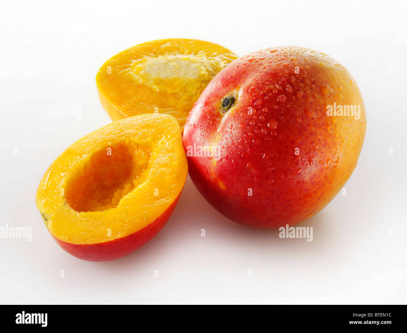 Frische ganze und geschnittene Mango vor einem weißen Hintergrund für ausgeschnitten Stockfoto