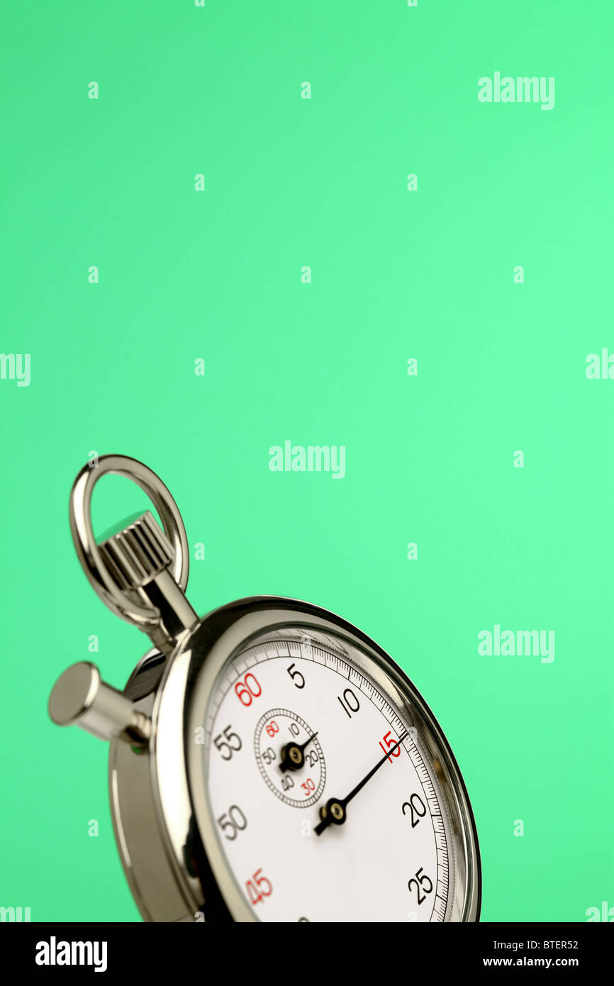 Eine Stoppuhr Zeitmessgerät schwimmend auf einem grünen Hintergrund Stockfoto