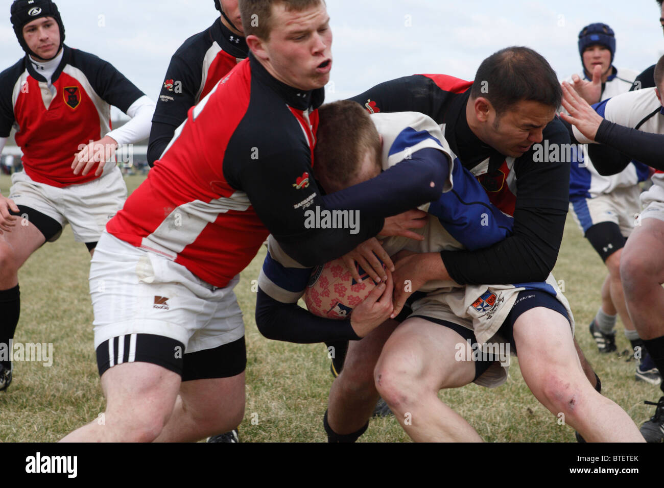 Ein Virginia University Spieler wird durch Cornell Spieler während eines Spiels auf der jährlichen Cherry Blossom-Rugby-Turnier in Angriff genommen. Stockfoto