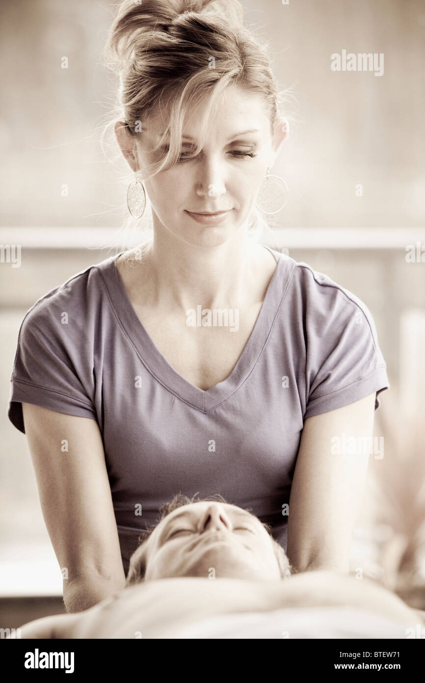 Frau, dass einem Mann eine ganzheitliche hawaiianische Lomilomi massage Stockfoto