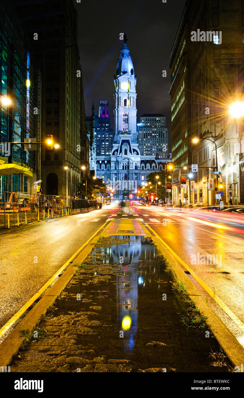 Rathaus von Broad Street nach Regen mit Verkehr Streifen gesehen. Reflexion des Rathauses in der Pfütze Mitte des Rahmens. Stockfoto