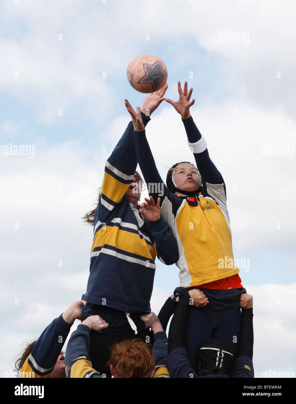 George Washington University Spieler (l) und Marine-Akademie Gegner (R) für den Ball während einer Frauen Rugby-Spiel zu erreichen. Stockfoto
