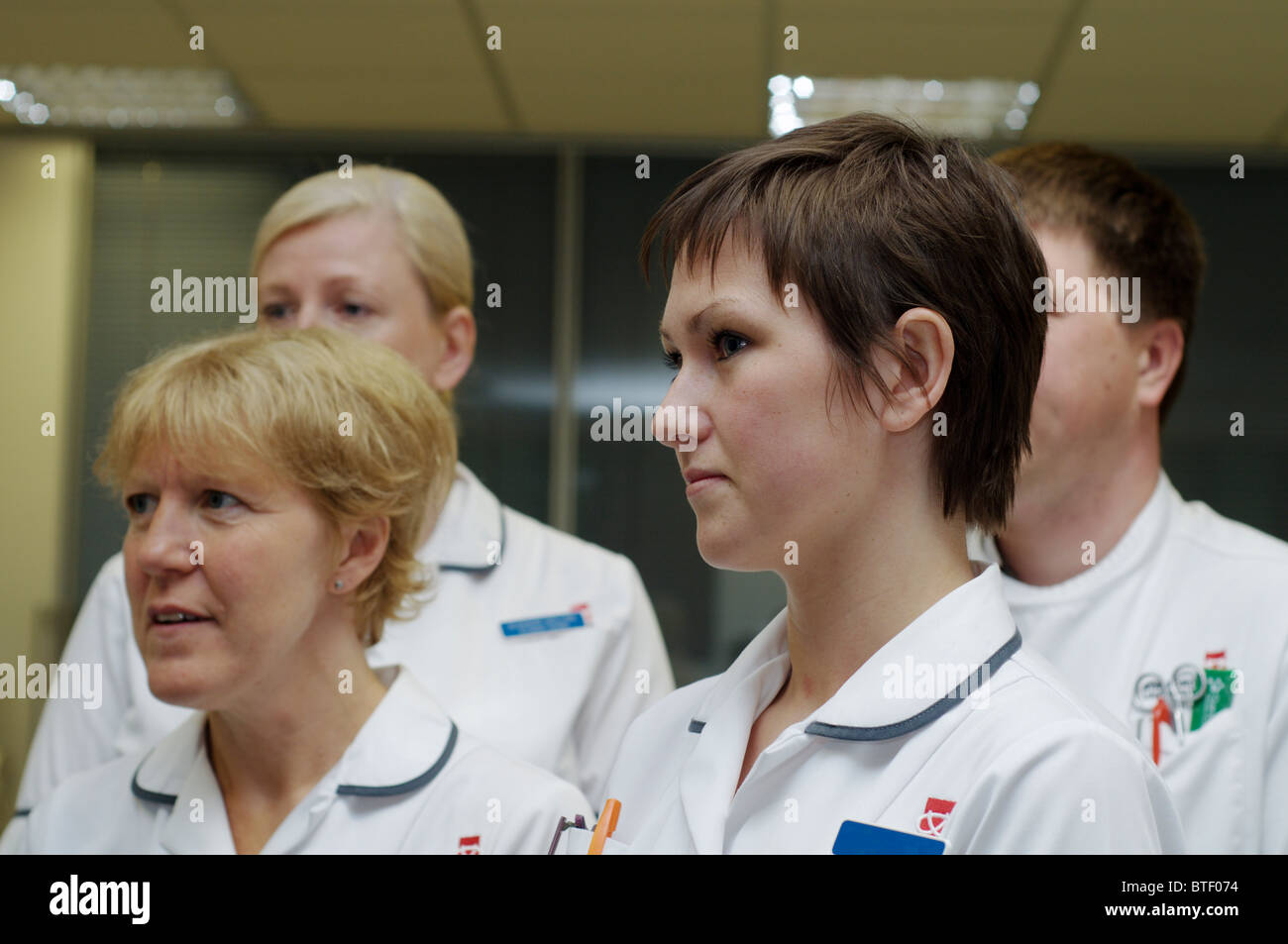 Gruppe von Lernschwestern, männlich und weiblich, in einer Gemeinde Lehrkrankenhaus hören während des medizinischen Trainings Stockfoto