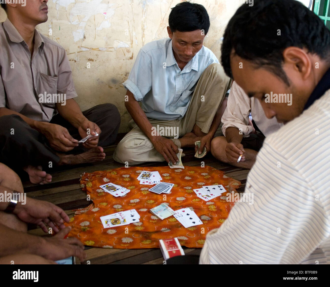 Eine Gruppe von Männern sind Glücksspiele und Spielkarten auf einer Straße in Kampong Cham, Kambodscha. Stockfoto