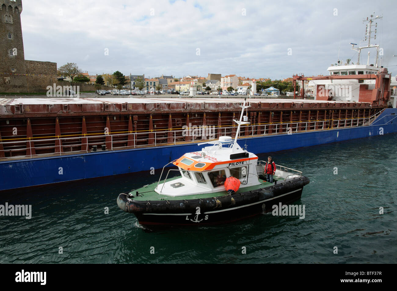 Lotsenboot eskortierte die Amurdiep trockenen Frachtschiff Manövrieren im Kanal bei der Abfahrt von Les Sables D' Olonne Frankreich Stockfoto