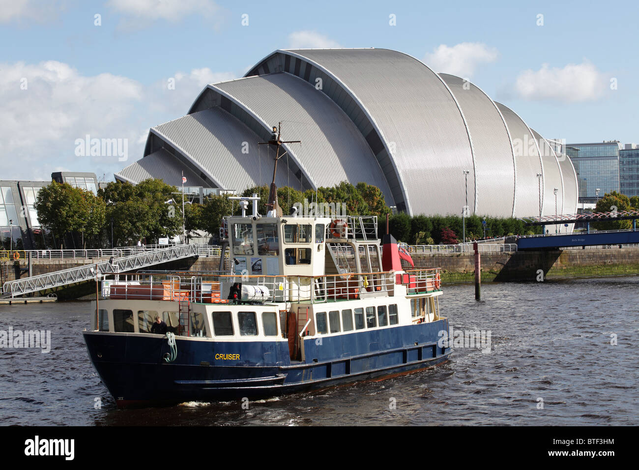 MV Cruiser Boot segelt auf dem Fluss Clyde neben der SEC Armadillo in Glasgow, Schottland, UK Stockfoto