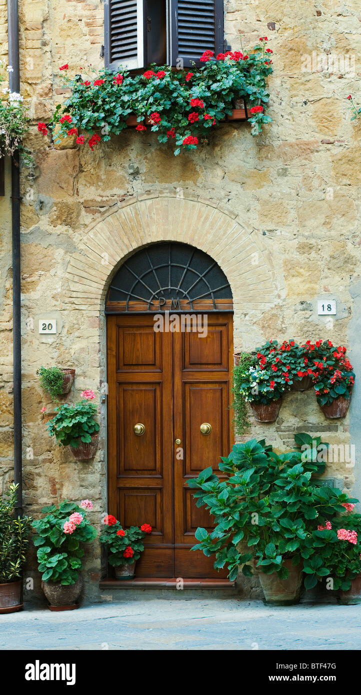 Pienza, Tür mit Töpfen von Granium Blumen, Toskana, Italien Stockfoto