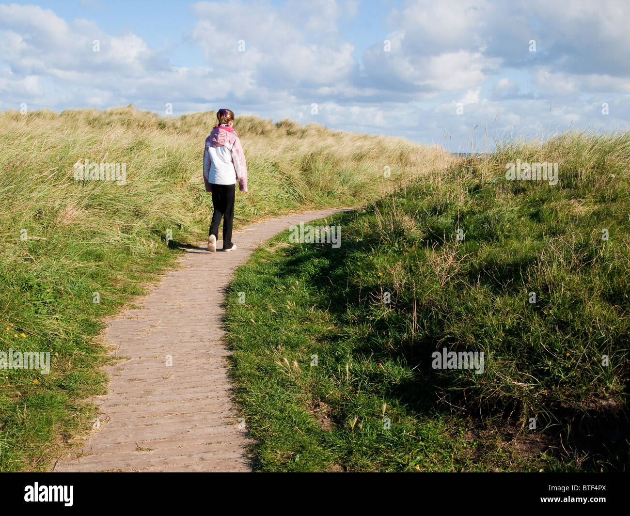 Mädchen zu Fuß entlang der Küste entlang Stockfoto