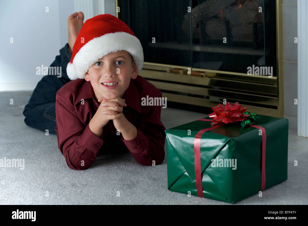 Ein acht Jahre alter Junge, die darauf warten, ein Geschenk zu öffnen Stockfoto