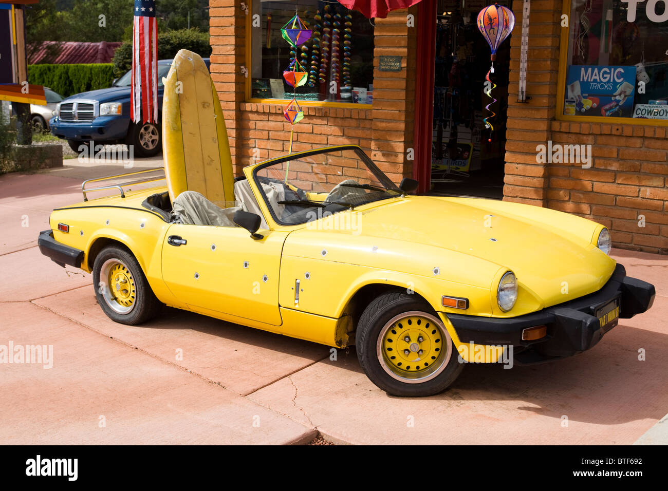 1979 gelb Triumph Spitfire mit Surfbrett im Rücksitz Stockfoto