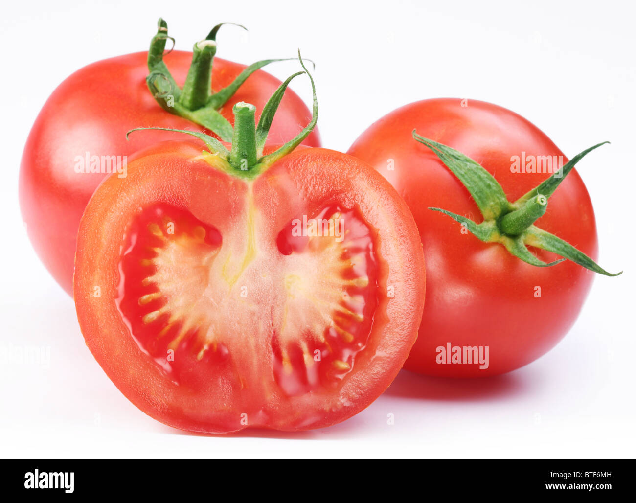 Gruppe von reifen Tomaten und die Hälfte. Isoliert auf weißem Hintergrund. Stockfoto