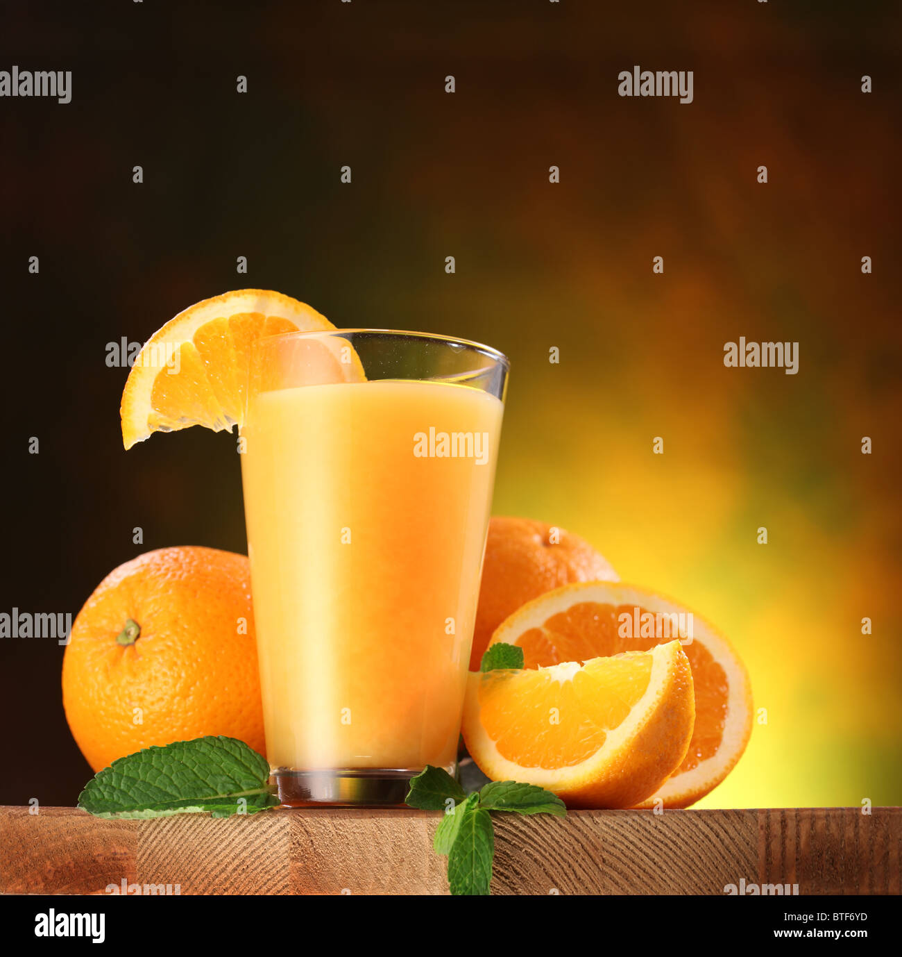 Stillleben: Orangen und Glas Saft auf einem Holztisch. Stockfoto