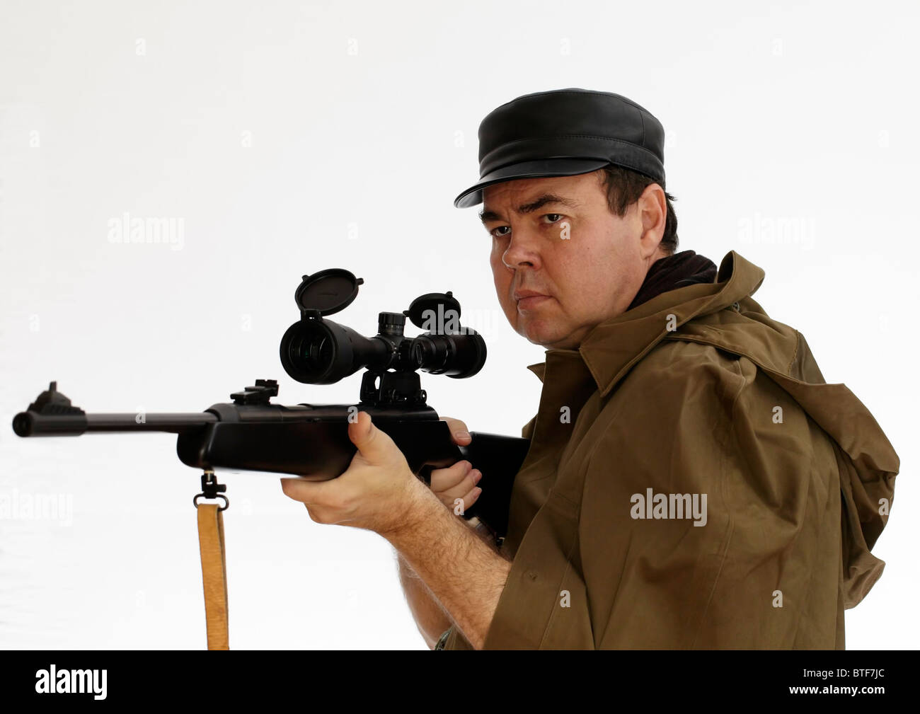 Mann mittleren Alters in Schutzkleidung mit einem Gewehr mit Zielfernrohr Stockfoto