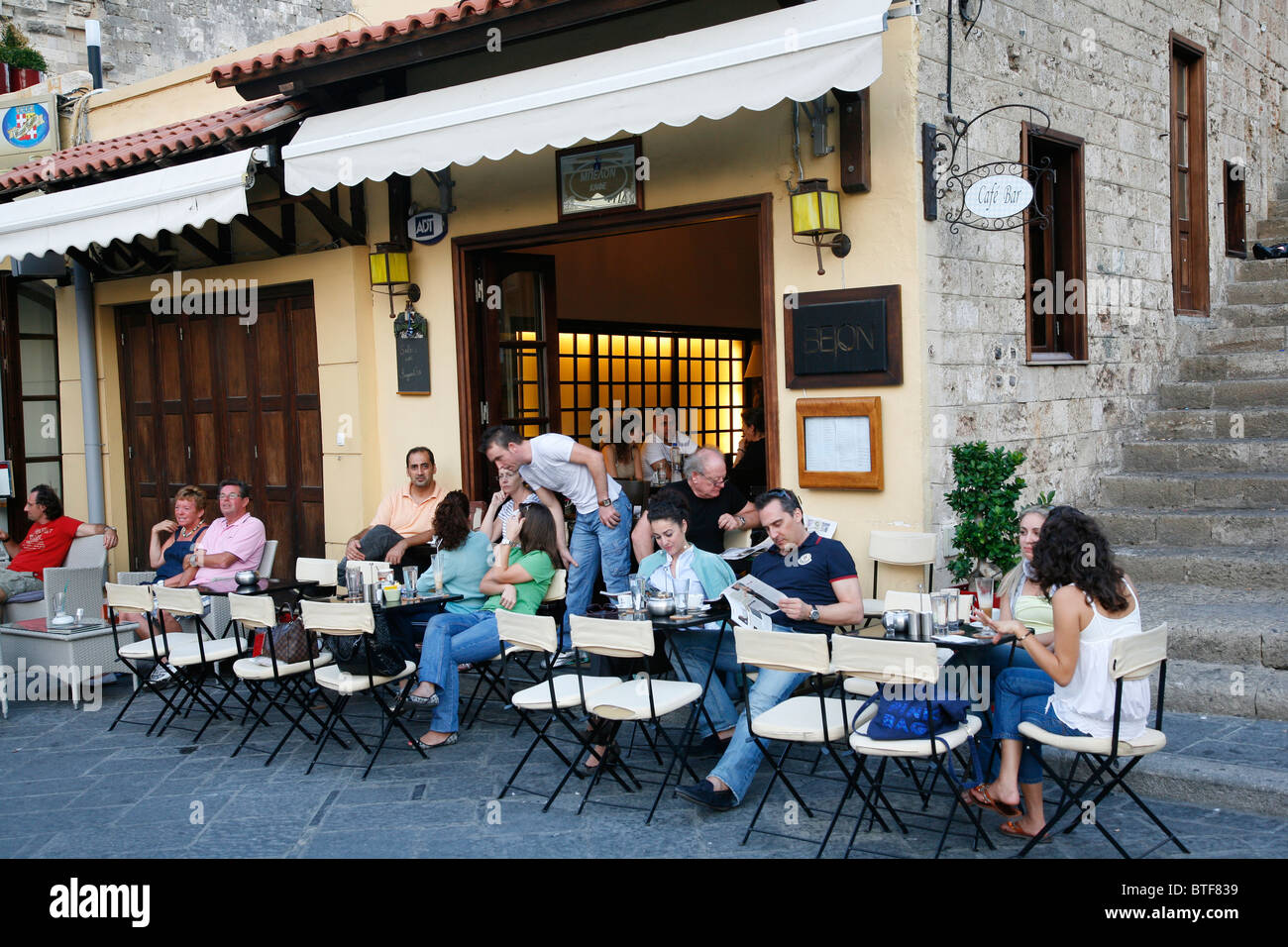 Menschen sitzen in einem Café in der Altstadt von Rhodos, Rhodos, Griechenland. Stockfoto