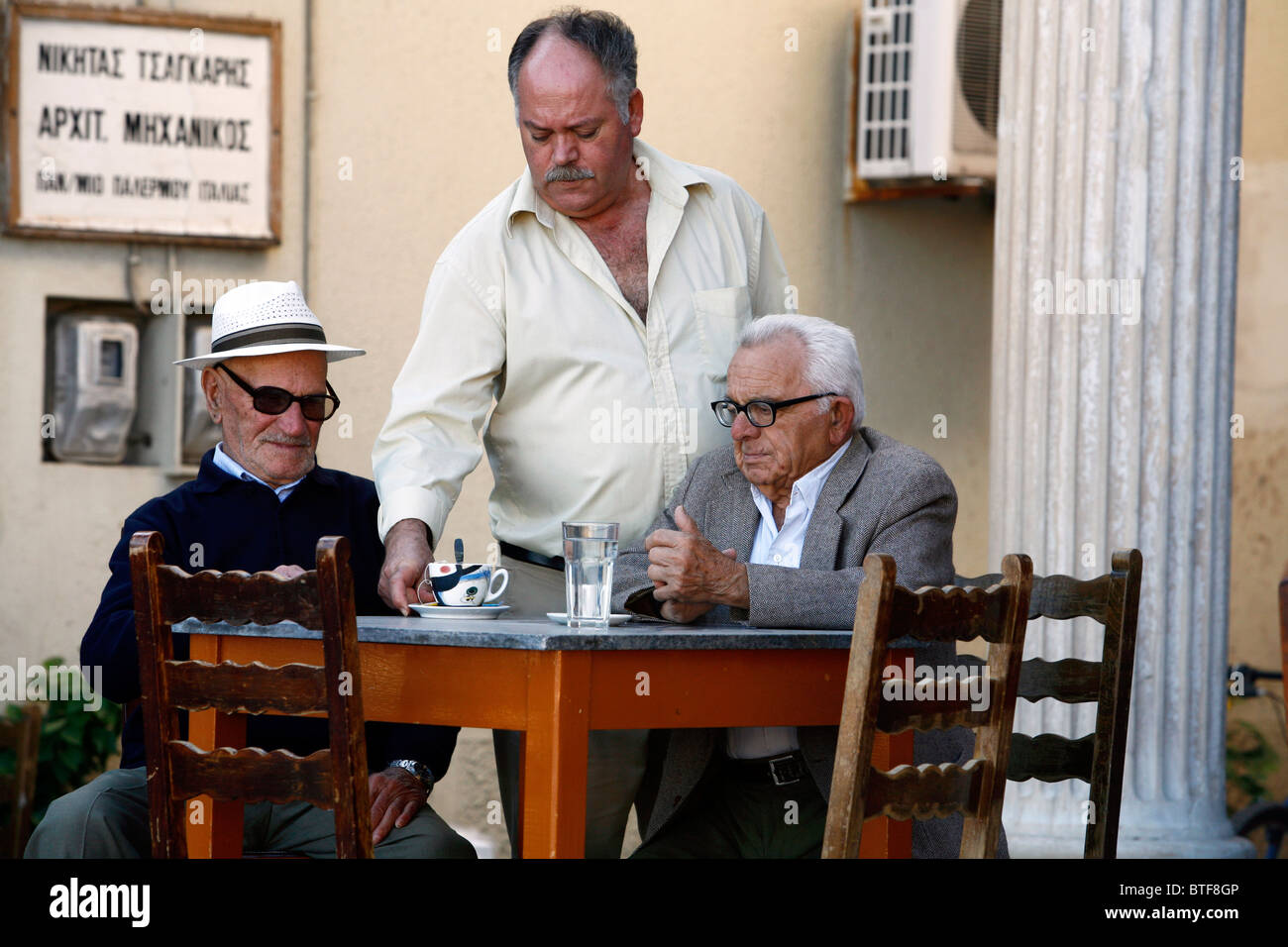Alte Männer sitzen an einem Kafenion, traditionelle Herren Café in Pothia, Kalymnos, Griechenland, Stockfoto