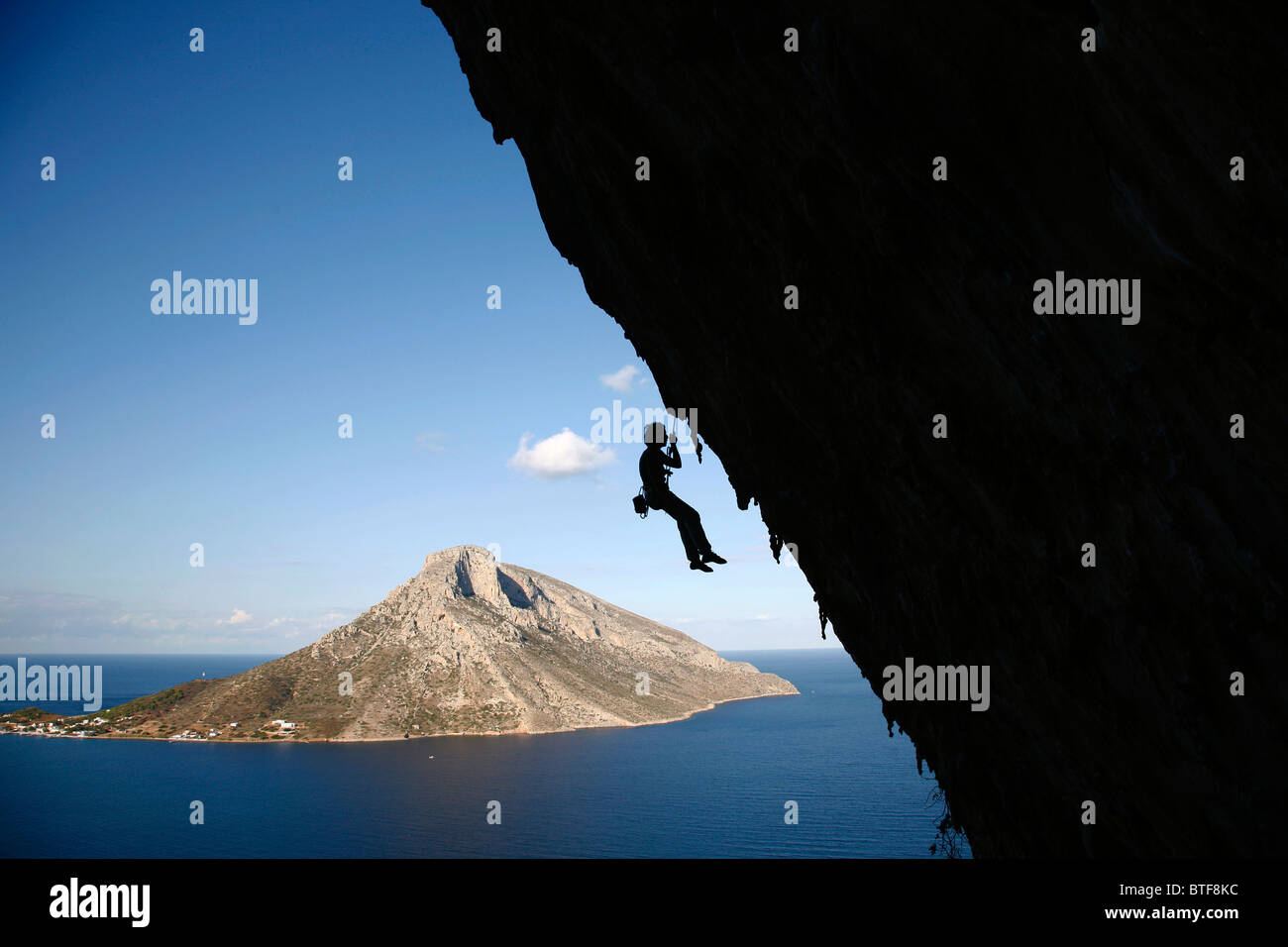 Klettern in in Grande Grotta Höhle mit der Insel Telendos im Hintergrund, Kalymnos, Griechenland, Stockfoto