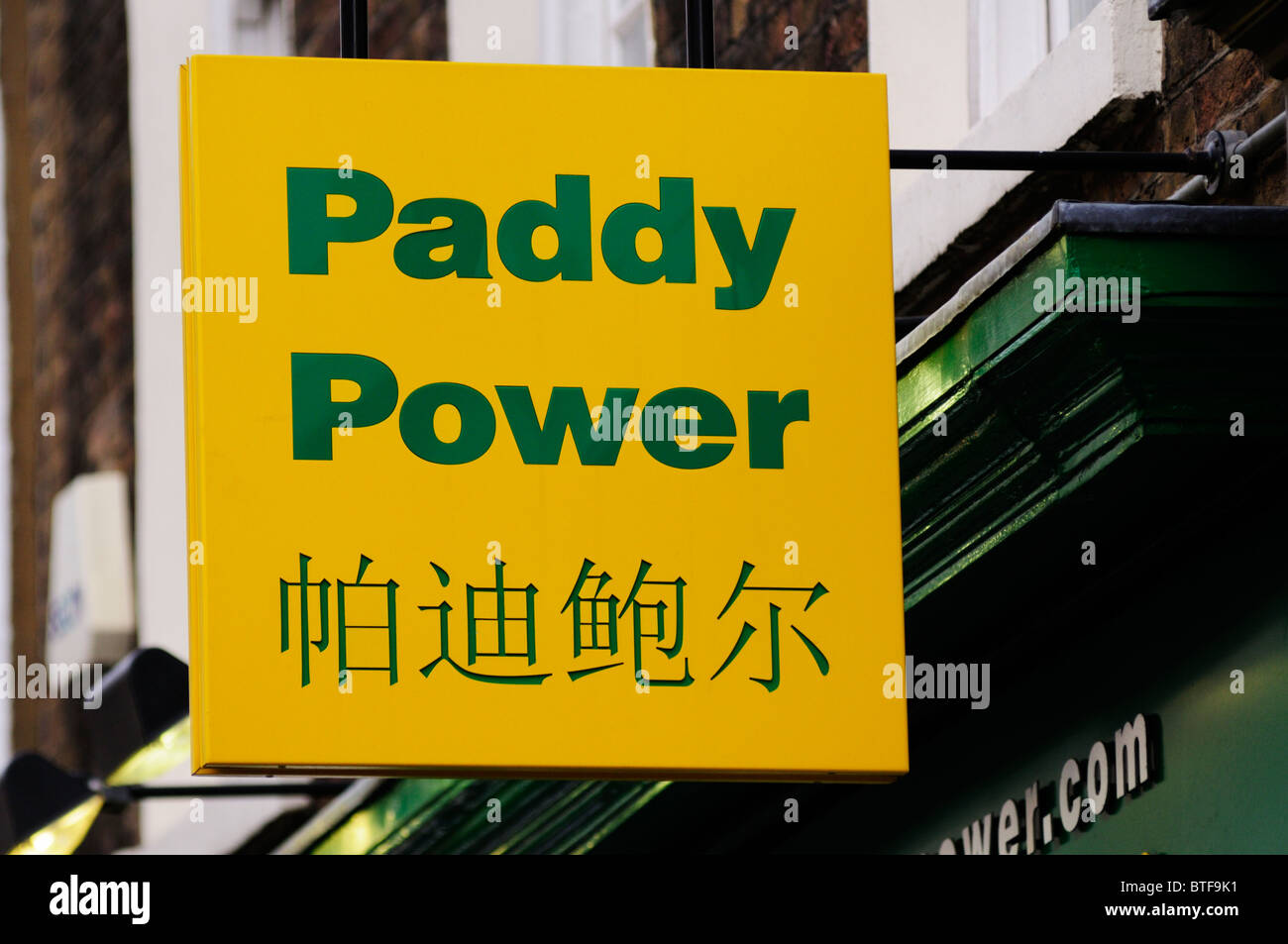 Zweisprachige Paddy Power Buchmacher Zeichen, Gerrard Street, Chinatown, London, England, UK Stockfoto