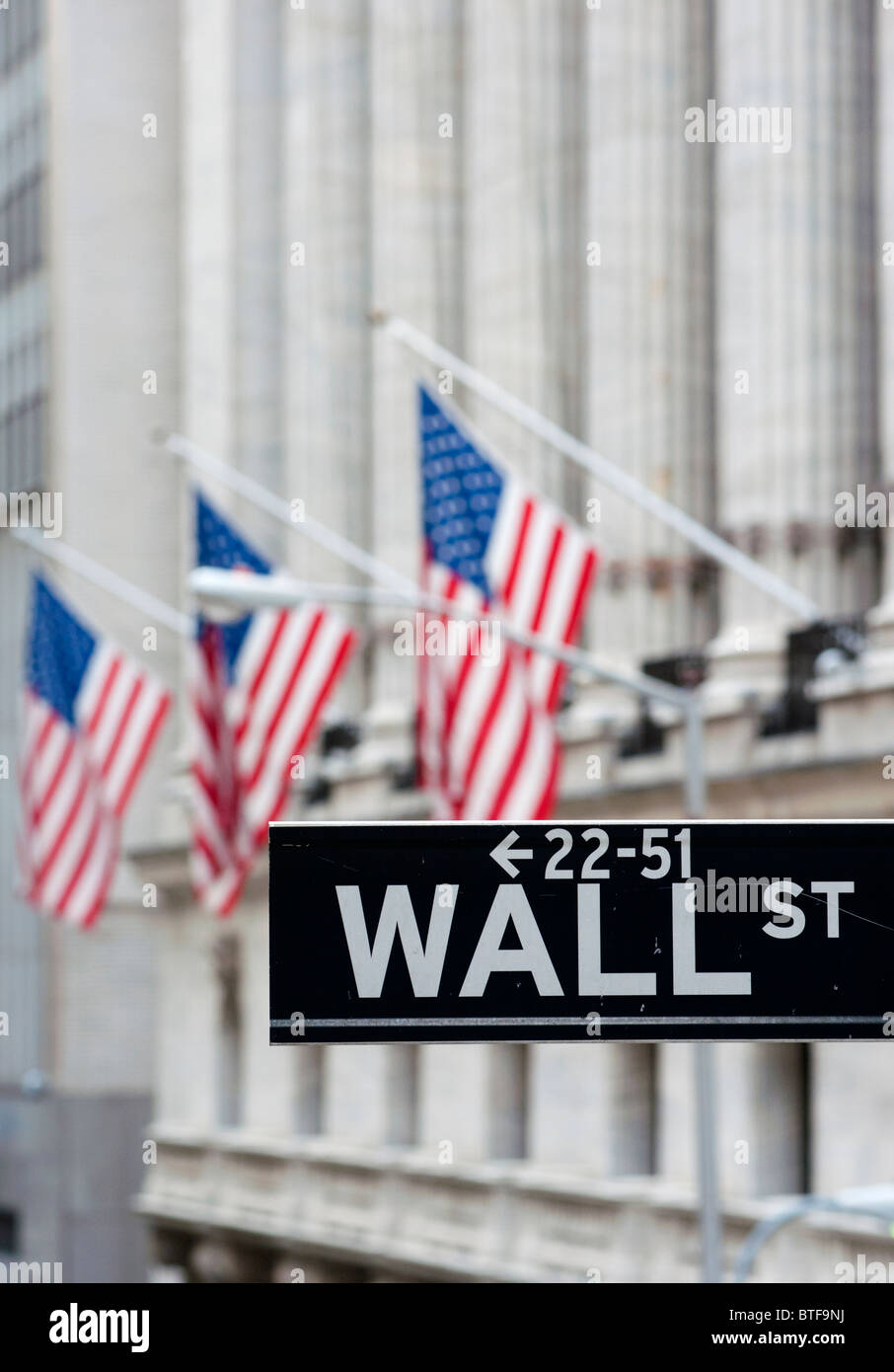 Detail der Wall-Street-Schild mit Flaggen auf Börsengebäude nach hinten Manhattan New York City Stockfoto
