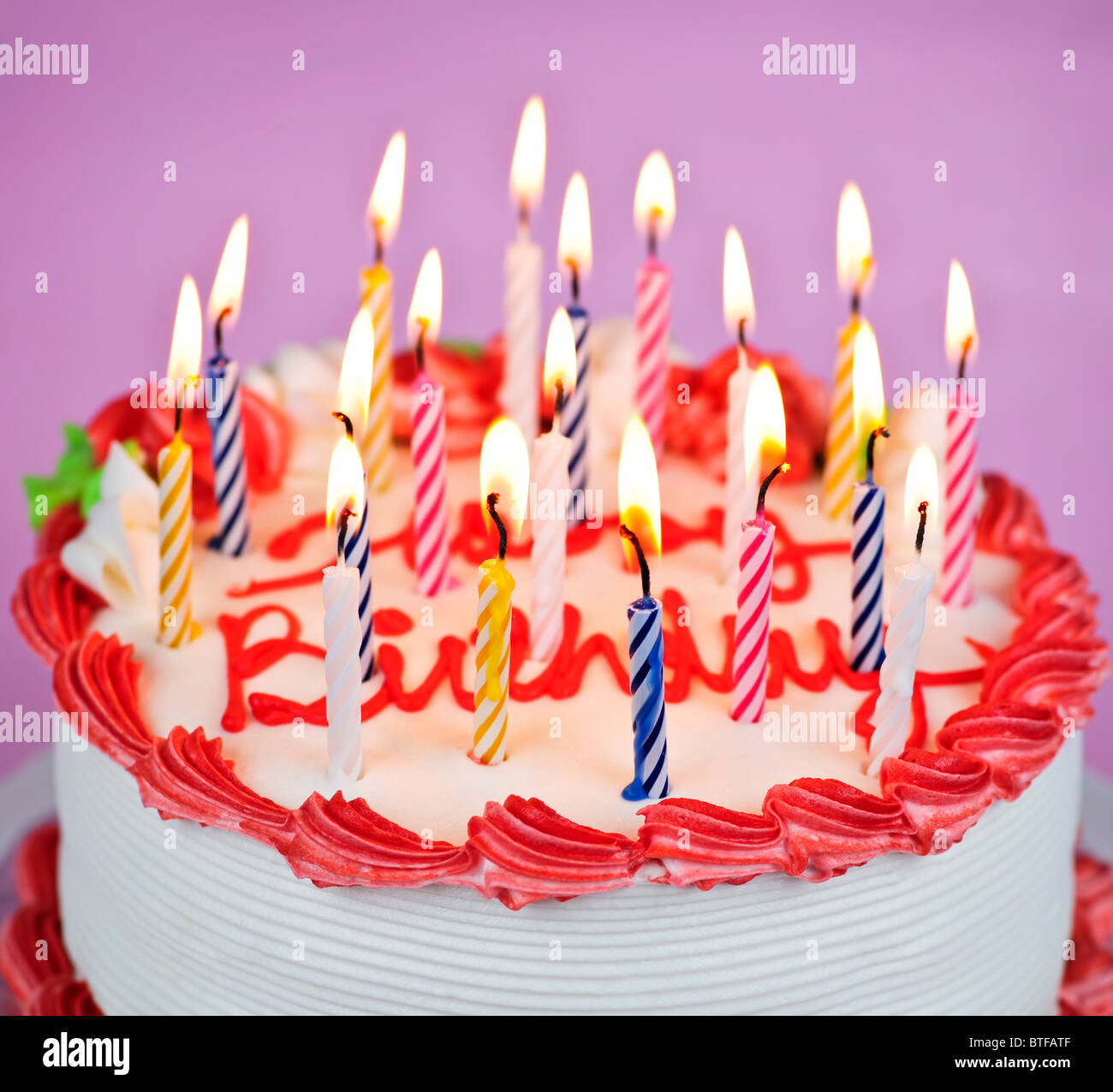 Geburtstagstorte mit brennenden Kerzen und Sahnehäubchen Stockfoto