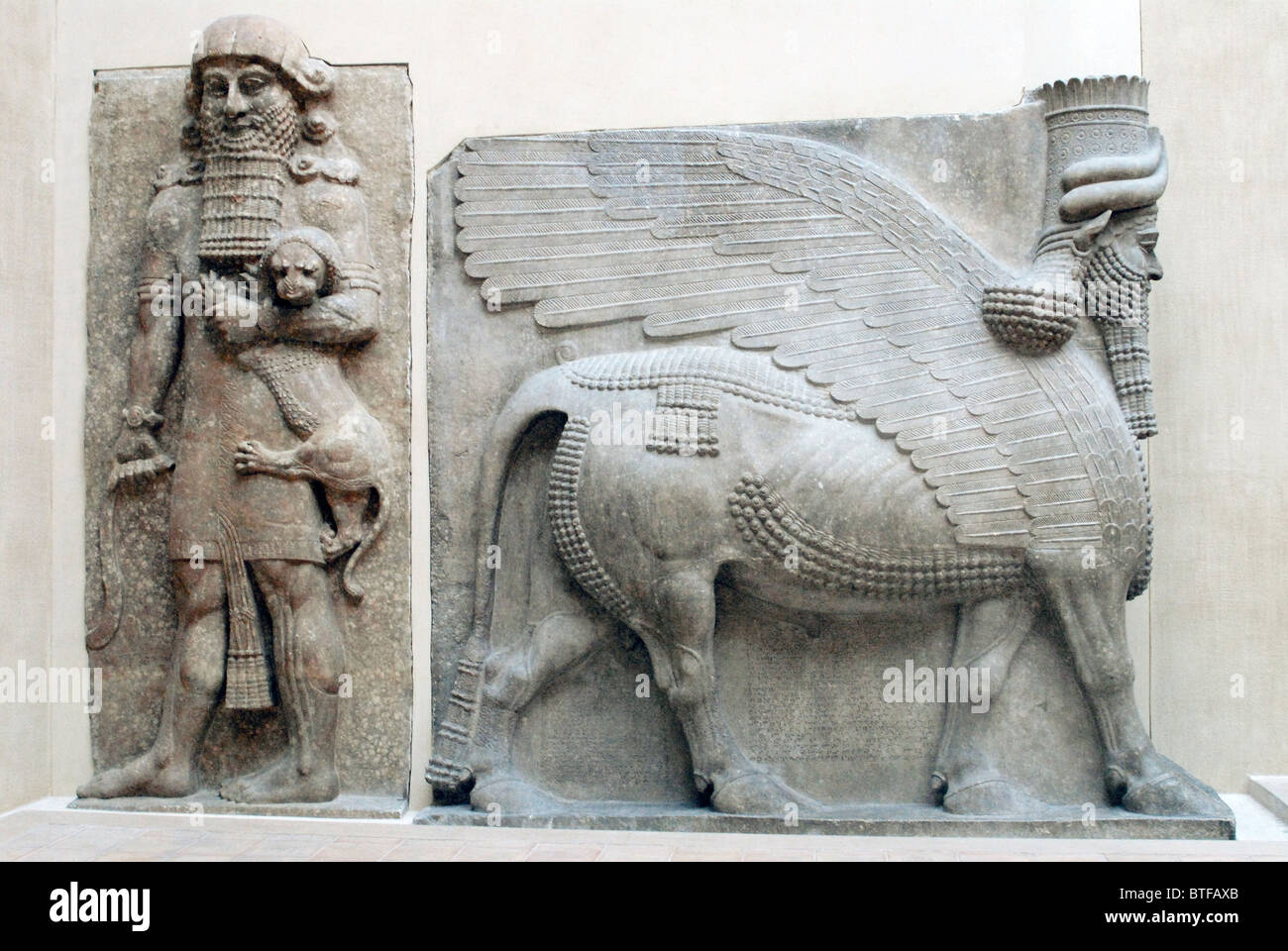 Geflügelte Mensch-headed Bull. Menschliche Figur mit Löwenbaby. Sumerische und babylonische Kunst. Louvre-Museum Stockfoto