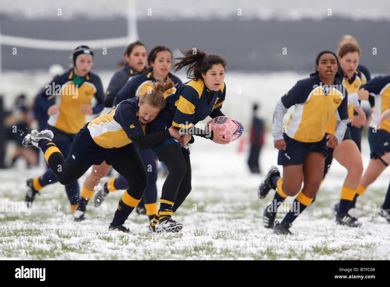 George Washington University Spieler trägt den Ball gegen die Marineakademie in einer verschneiten Frauen Rugby-Spiel. Stockfoto
