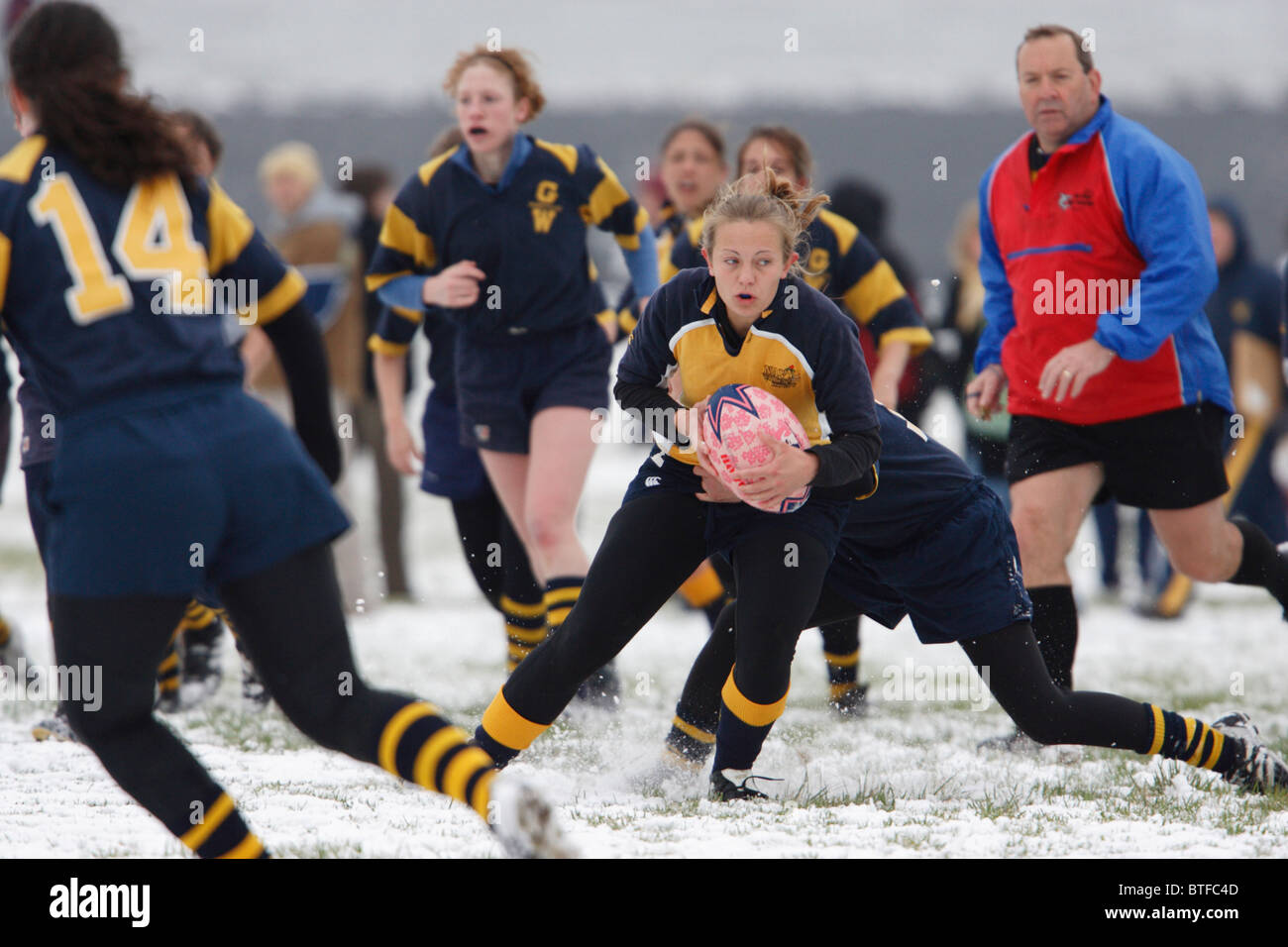 Eine Marineakademie Ballträger in Aktion während einer verschneiten Frauen Rugby-match gegen George Washington University. Stockfoto