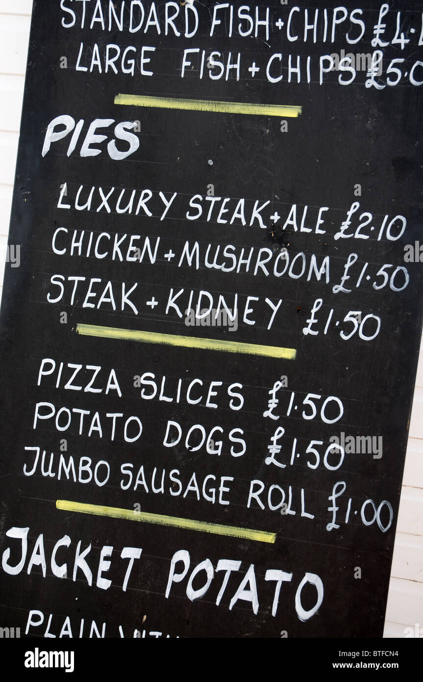geschrieben in weißer Kreide auf eine Tafel zeigt typisch britisches Essen Kuchen Pommes und Pizza zum Mitnehmen-Menü Stockfoto