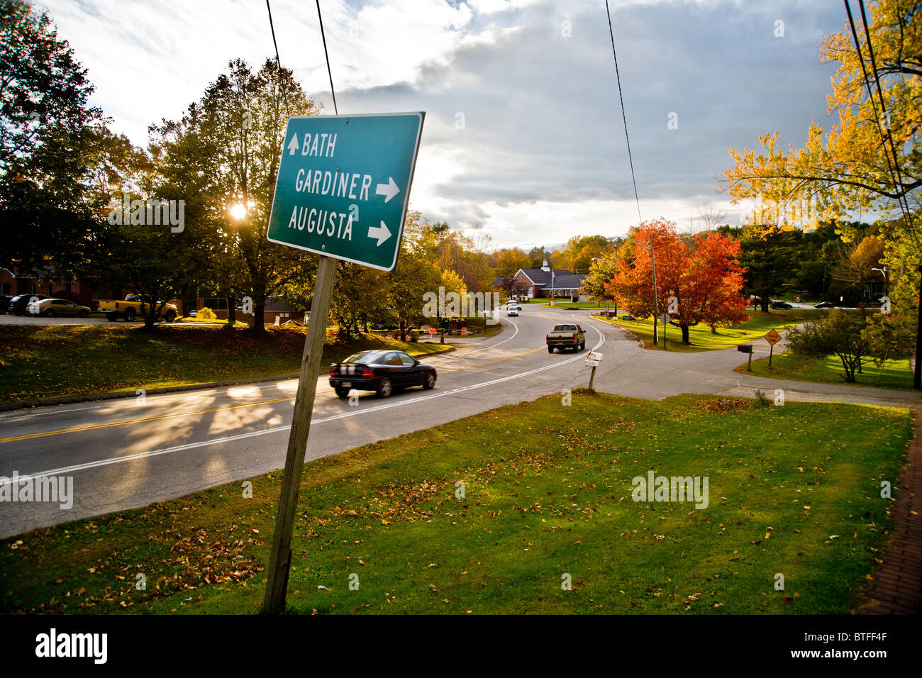 Herbstsonne leuchtet auf in Richtung Süden Verkehr auf Route 1 in Wiscasset, Maine. Beachten Sie die Beschilderung und bunte Blätter. Stockfoto