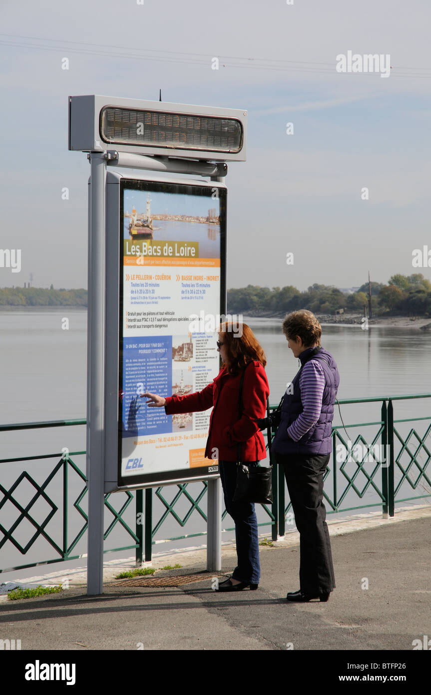 Frauen lesen eine Fähre Informationstafel neben dem Fluss Loire bei Le Pellerin in der Nähe von Nantes Frankreich Stockfoto